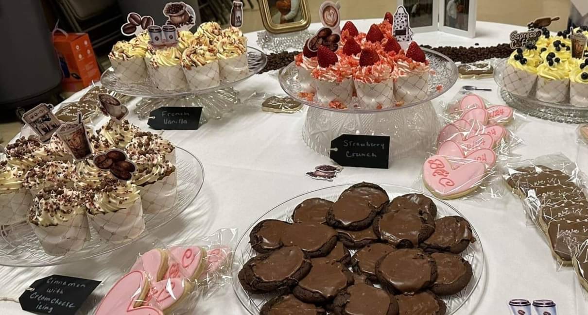 Dessert table with several cupcake flavors and decorated treats