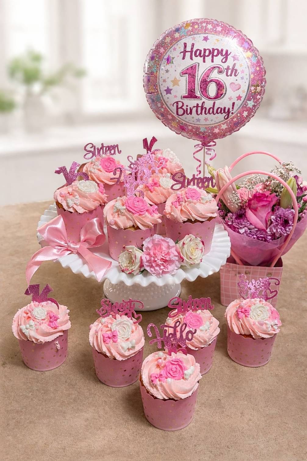 Pink decorated birthday cupcakes with a sixteenth birthday balloon